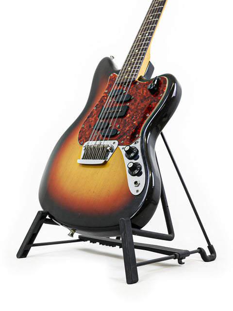 1966 Fender Electric XII guitar on a stand, with a minimalist white background, showcasing its vintage charm and style.