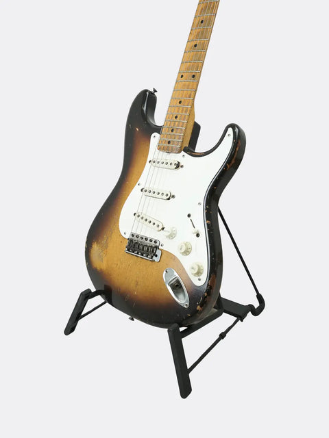 Fender Stratocaster guitar on a stand against a white background