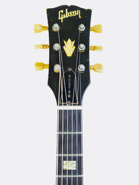 Gibson ES-335 guitar headstock with brand logo on a white background
