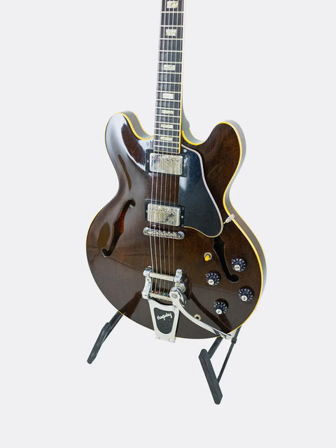 Gibson ES-335 guitar on a stand against a white background