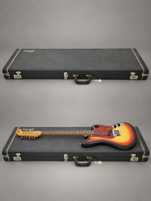 Two classic Fender Electric XII guitars from 1965 resting in a case, set on a bright white background.