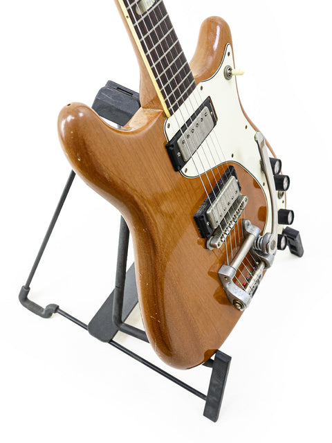 4. A vintage Epiphone Crestwood Custom guitar from 1964 on a stand, highlighted by a plain white background.
