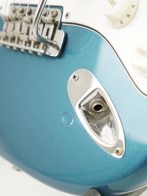 Detailed view of a blue electric guitar, a vintage 1965 Fender Stratocaster, highlighting its iconic features.