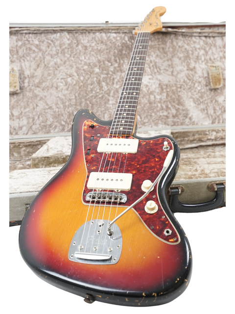 A 1962 Fender Jazzmaster guitar and case, elegantly placed on a white background.