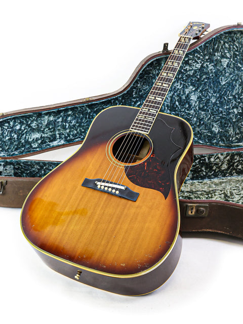 A 1964 Gibson Southern Jumbo guitar securely placed in its case, reflecting the elegance of vintage American craftsmanship.