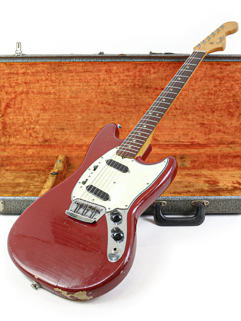 A 1966 Fender Musicmaster II guitar in a case, featuring a striking wooden top, embodying timeless vintage style and craftsmanship.