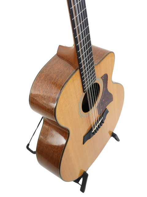 A 1995 Taylor LKSM Leo Kottke 12-string guitar on a stand, featuring its unique design and rich wood finish.