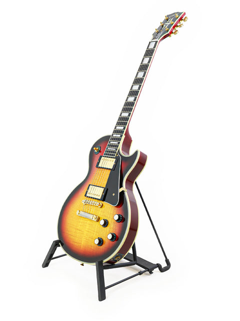 A 2006 Gibson Custom Shop '68 Reissue Les Paul Custom guitar elegantly positioned on a stand with a white background.