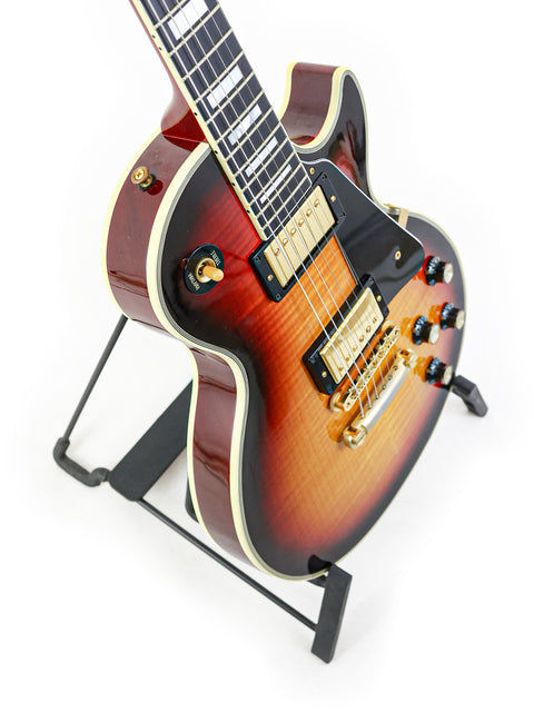 A 2006 USA-made Gibson Custom Shop '68 Reissue Les Paul Custom guitar with a black body and eye-catching red neck.