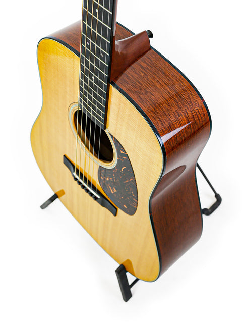 A 2012 Martin D-18 acoustic guitar resting on a stand, highlighting its compact size and beautiful craftsmanship.
