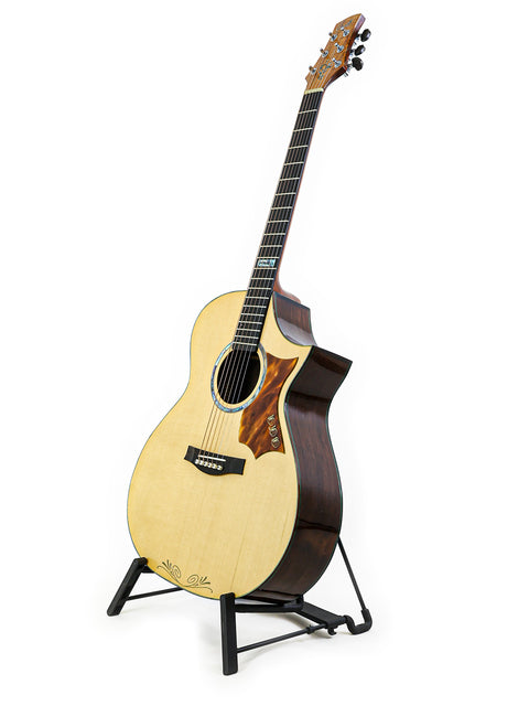 A 2015 James Cargill Custom guitar displayed on a stand, set against a minimalist white background, highlighting its craftsmanship.