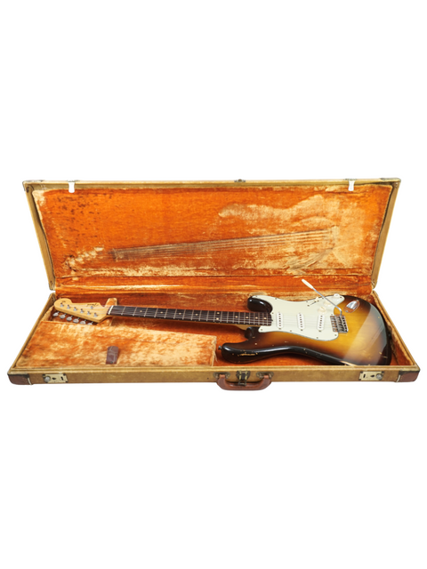A '67 Fender Stratocaster rests in a vintage case, representing the classic slab board style, a nod to USA craftsmanship from 1959.