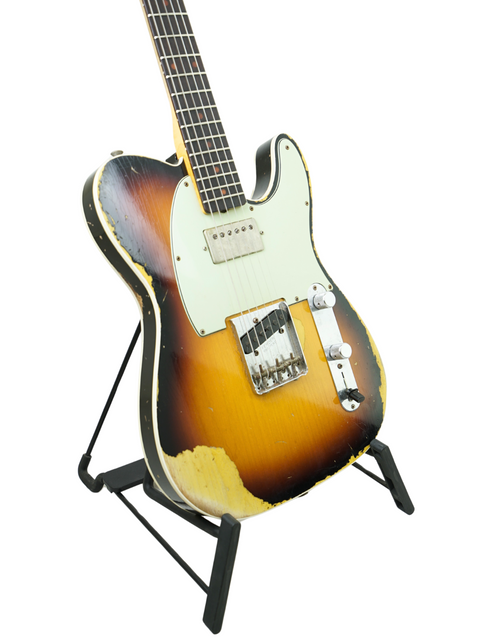 A Fender Custom Shop 60s Telecaster with a sunburst finish displayed on a stand, showcasing its aged relic design.