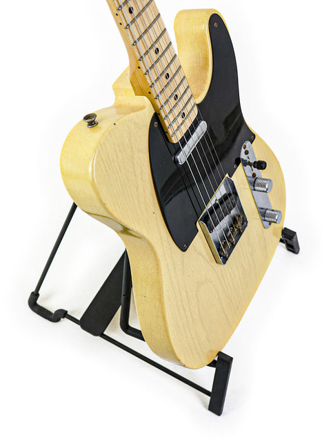 A Fender Custom Shop 70th Anniversary Broadcaster guitar displayed on a stand against a clean white background.