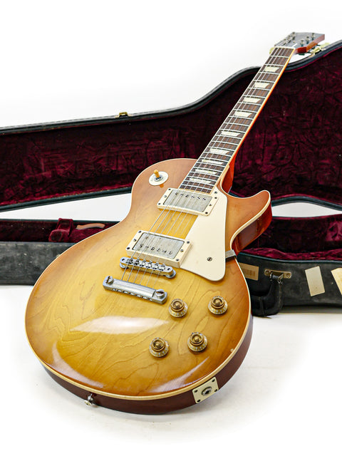 A Gibson Custom Shop LPR-8 1958 Les Paul Reissue guitar comfortably resting in its case, perfect for musicians and collectors alike.