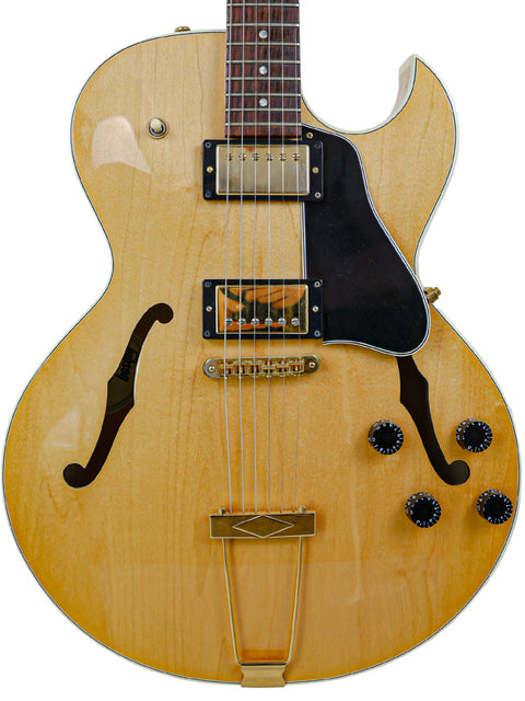 A Gibson ES-135 guitar from 2002 featuring a sleek white pickguard, showcasing its classic design and craftsmanship.