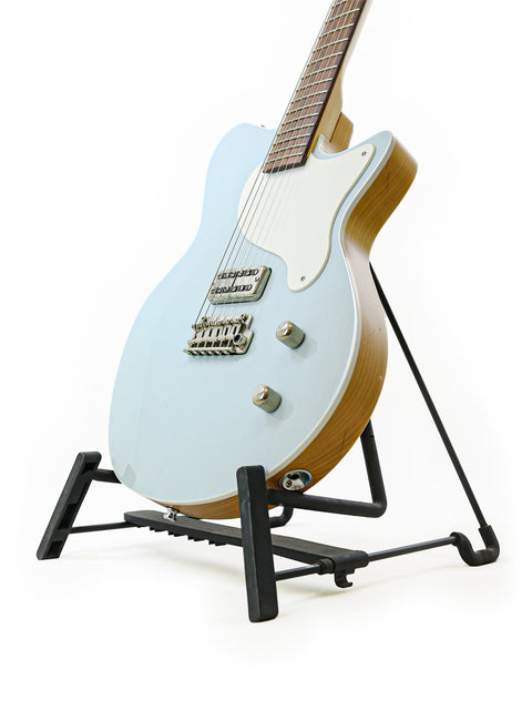 A Koll Troubadour guitar displayed on a stand, set against a bright white backdrop, highlighting its beautiful features