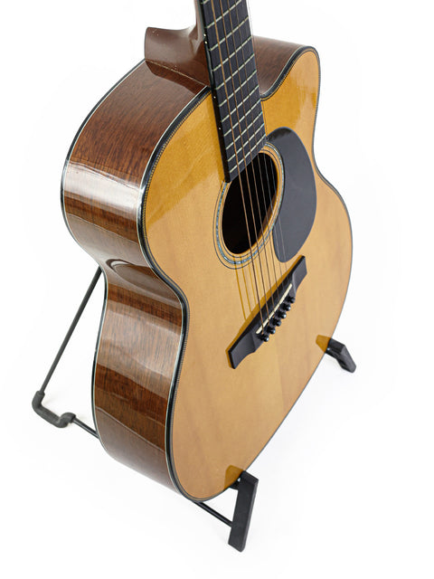 A Martin 000-C David Gray Custom guitar displayed on a stand, highlighting its unique features and prototype status from 2004.