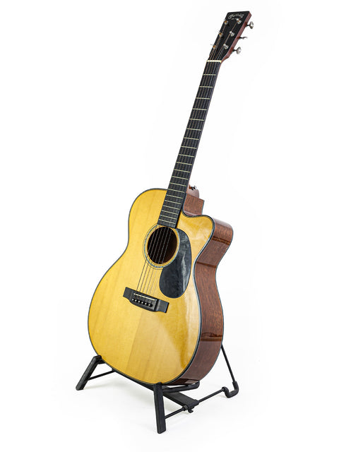 A Martin 000-C David Gray Custom guitar from 2004, resting on a stand against a bright white background, highlighting its craftsmanship.