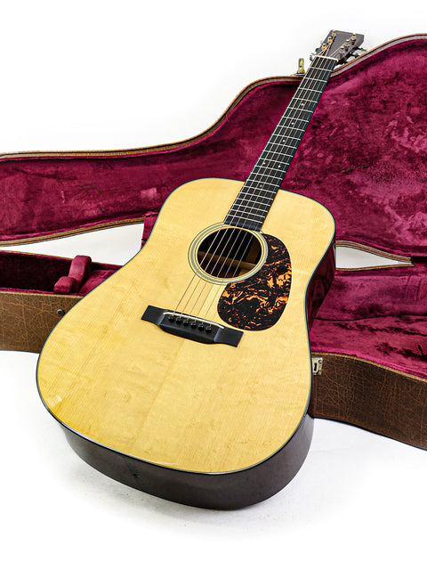 A Martin D-18 Authentic 1937 guitar displayed in a case, adorned with a plush red velvet lining for protection.