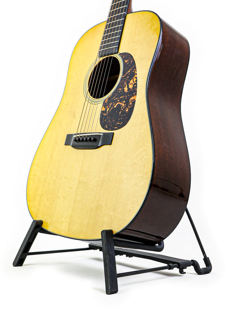 A Martin D-18 Authentic 1937 guitar elegantly positioned on a stand with a plain white background.
