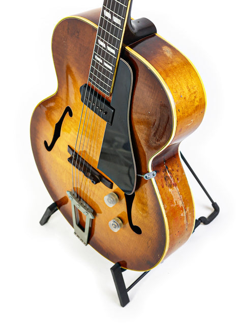 A beautifully crafted 1946 Gibson ES-300 guitar on a stand, representing timeless elegance in vintage musical instruments.