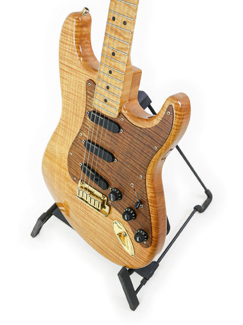 A beautifully crafted 1992 Fender Custom Shop 'Clapton' Stratocaster guitar, featuring a wooden body and stylish black hardware.