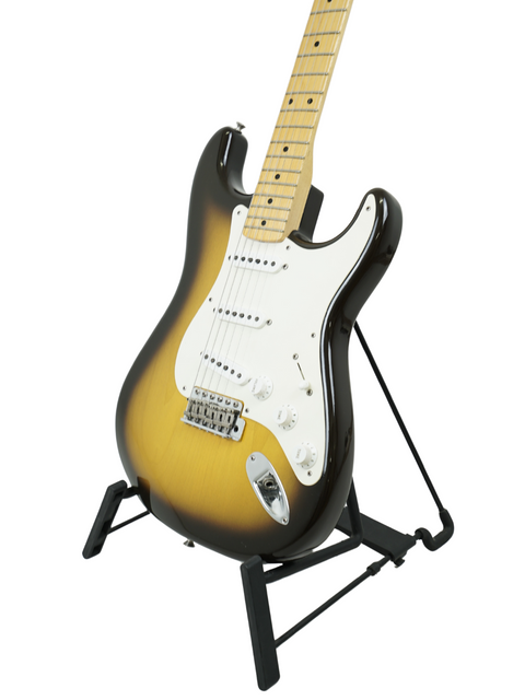 A beautifully crafted Fender '56 Stratocaster guitar on a stand, presented against a deep black background.
