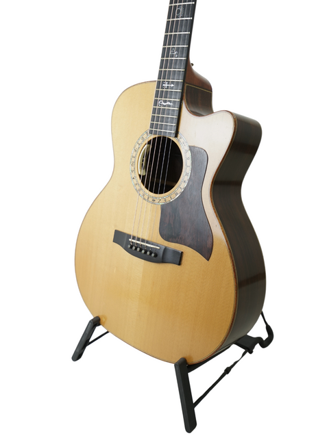 A beautifully crafted Lakewood M-NC CP New Century II Grand Concert guitar resting on a stand, highlighting its design.