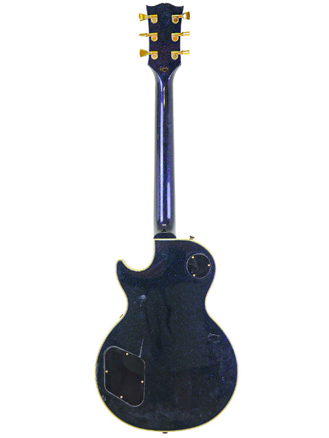 A black guitar featuring a blue body and neck, identified as a 1991 Gibson Custom Shop Les Paul Custom from the USA.