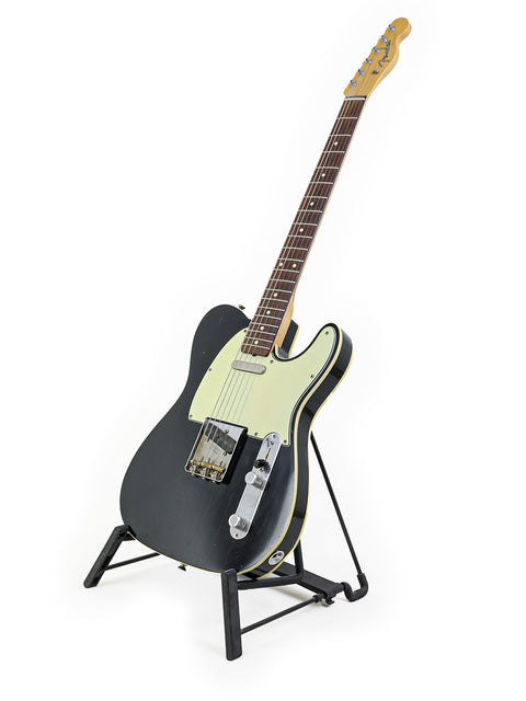 A black guitar, the Fender '59 Custom Telecaster, stands prominently against a white background.