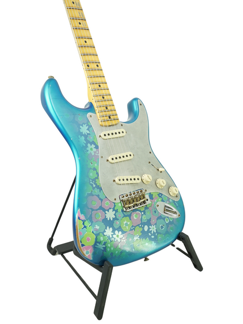 A blue Fender Custom Shop EL Diablo Strat guitar adorned with colorful flowers, showcasing its unique design.