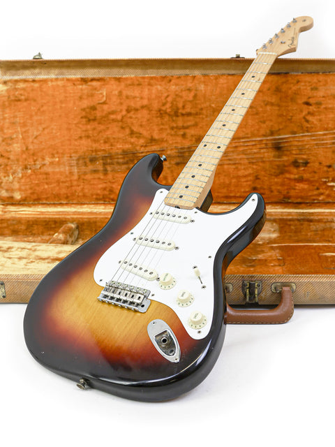 A classic 1958 Fender Stratocaster guitar displayed in a wooden case, representing a piece of musical history.