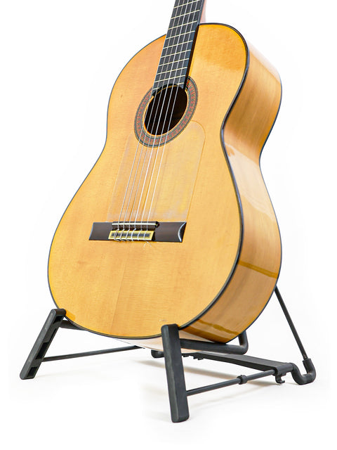 A classic José Ramírez 2A guitar displayed on a stand, set against a stark white background, highlighting its Spanish heritage from 1963.