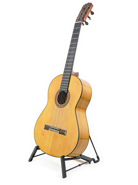 A classic José Ramírez 2A guitar displayed on a stand, with a minimalist white backdrop highlighting its craftsmanship.