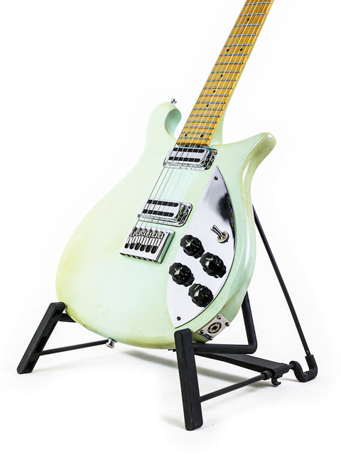 A green Rickenbacker 650C Colorado guitar on a stand against a clean white background, showcasing its vibrant color and design.