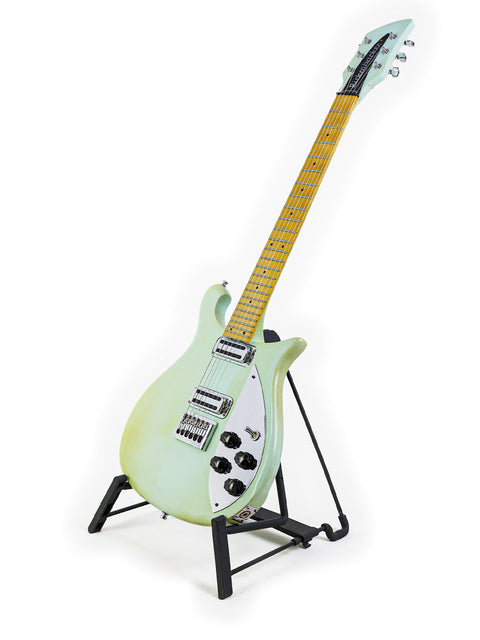 A green Rickenbacker 650C Colorado guitar resting on a stand, with a simple white background enhancing its bold appearance.