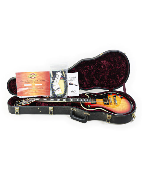 A guitar case containing a Gibson Custom Shop '68 Reissue Les Paul Custom, highlighting its elegant features and vintage appeal.
