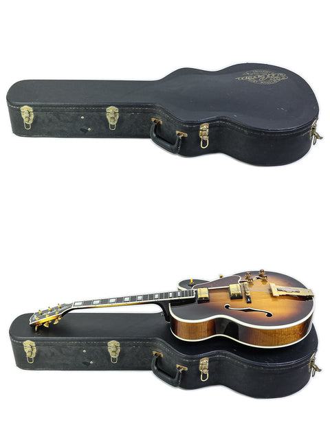 A pair of guitars, featuring a 2002 Gibson L-5 CES, displayed in their cases against a white backdrop.
