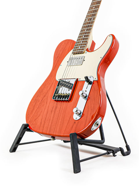 A red G&L Fullerton Deluxe ASAT Classic Bluesboy guitar displayed on a stand with a clean white backdrop.