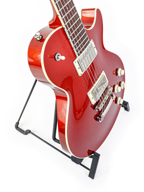 A red electric guitar, the Collings CL Deluxe 2019, elegantly displayed on a stand, showcasing its sleek design and craftsmanship.