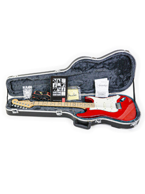 A red guitar case with a 1993 Fender Strat Plus Deluxe guitar nestled inside, showcasing its classic design.