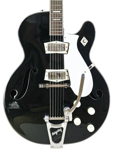 A sleek black Silvertone 1446 guitar featuring a white pickup, a vintage gem from 1961-65.