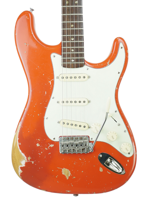 A striking orange 1979 Fender Stratocaster guitar featuring a sleek white pickguard, perfect for any music lover.