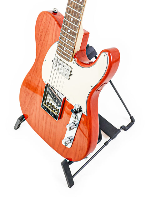 A striking red electric guitar, G&L Fullerton Deluxe ASAT Classic Bluesboy, positioned on a stand with a white background.