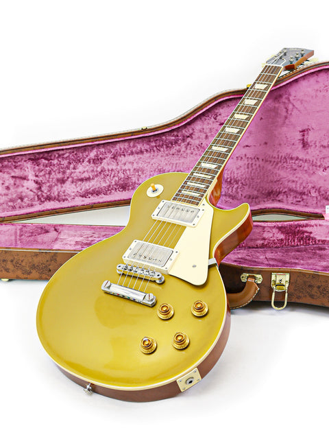 A stunning gold Les Paul Goldtop Reissue guitar nestled in a vibrant pink case, highlighting its 2019 craftsmanship.