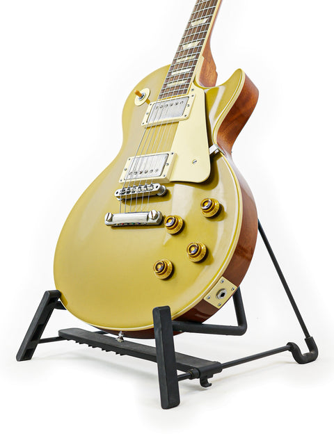 A vibrant yellow Gibson Custom Shop LPR-7 1957 Les Paul Goldtop guitar resting on a stand.
