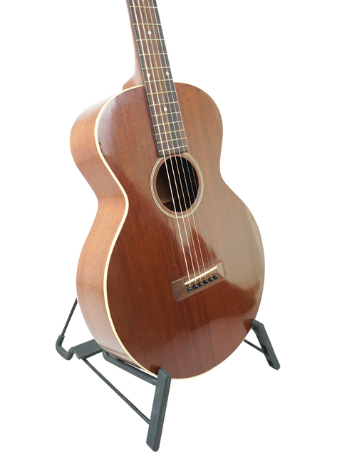 A vintage 1929 Gibson L-0 acoustic guitar resting on a stand, exemplifying timeless design and musical artistry.