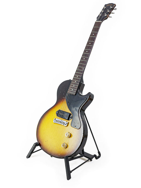 A vintage 1958 Gibson Les Paul Jr TV Yellow Refin guitar resting on a stand, set against a clean white background.