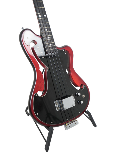A vintage 1966 Ampeg AEB-1 bass guitar in red and black, elegantly positioned on a stand.